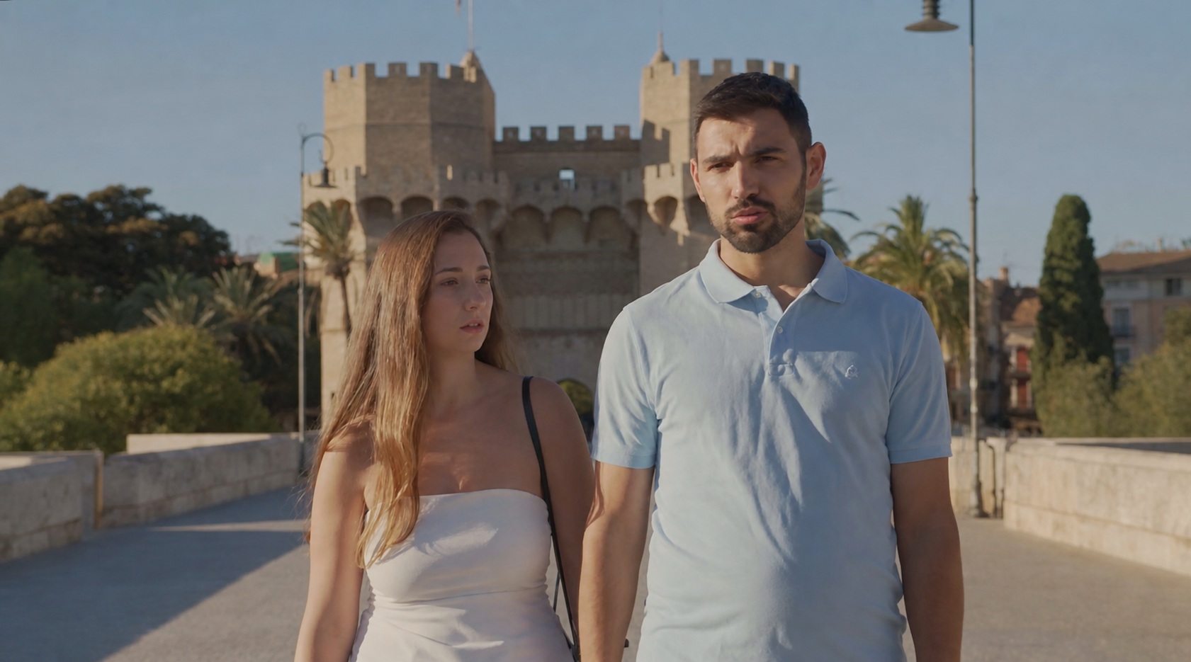 Pareja caminando frente a las Torres de Serranos de Valencia a la hora dorada, fotograma de ficción de ZF Studio